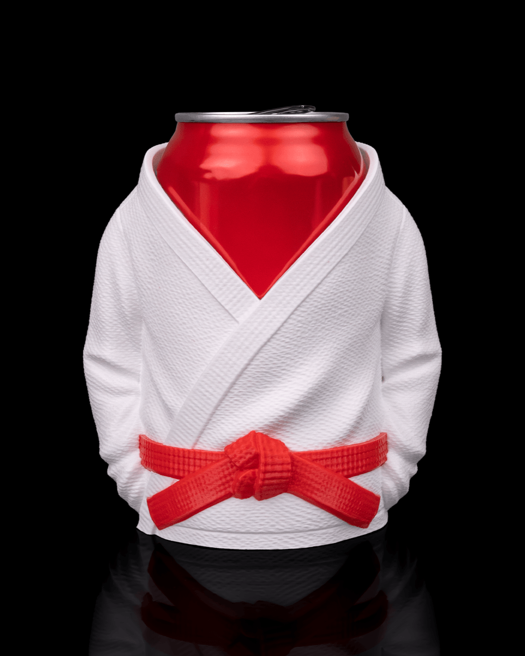 Porta lata kimono jiu jitsu impresso em 3D na cor branca com faixa vermelha, acomodando uma lata de alumínio vermelha sobre fundo preto.